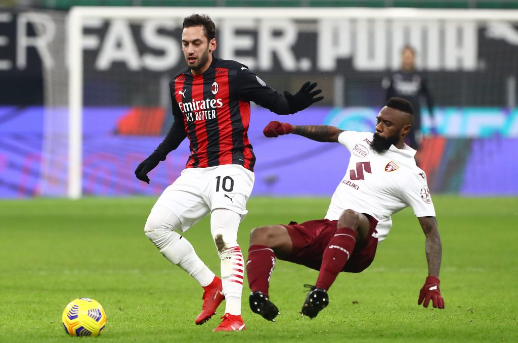 Calhanoglu del Milan protegge il pallone dall'attacco di Nkoulou del Torino