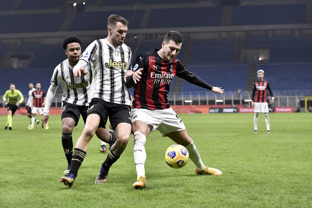 Diogo Dalot, terzino del Milan, protegge il pallone sull'attacco di Ramsey della Juventus