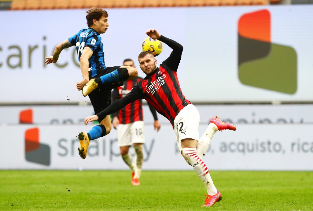 Nicolò Barella dell'Inter vola sulla palla contro Rebic del Milan